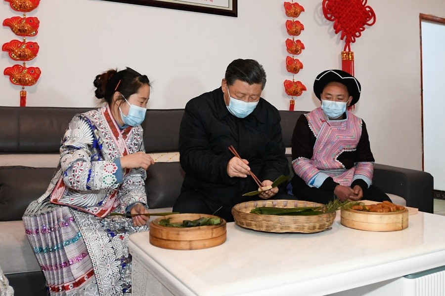 2021年2月3日下午，習(xí)近平在貴州畢節(jié)市黔西縣新仁苗族鄉(xiāng)化屋村苗族村民趙玉學(xué)家，同一家人邊聊家常邊制作當(dāng)?shù)貍鹘y(tǒng)節(jié)日食品黃粑。新華社記者 李學(xué)仁 攝